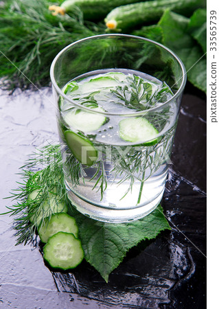 Cucumber water in glass with dill on black 33565739