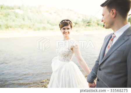 Bride and groom holding beautiful wedding bouquet Bride and groom holding beautiful wedding bouquet 33568275