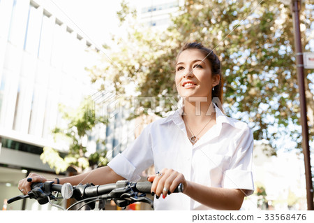 Portrait of happy young female bicyclist Portrait of happy young female bicyclist 33568476