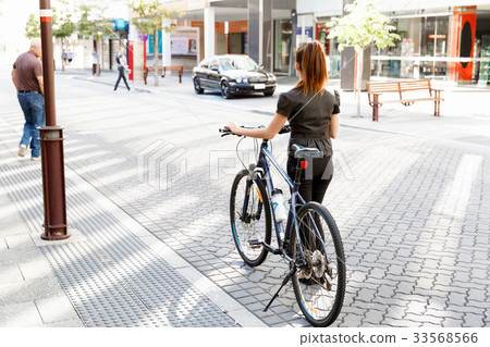 Young woman commuting on bicycle Young woman commuting on bicycle 33568566