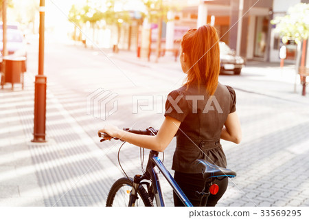 Young woman commuting on bicycle 33569295