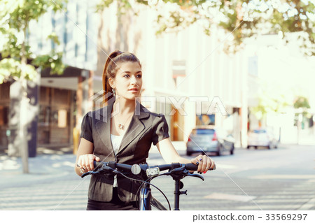 Young woman commuting on bicycle Young woman commuting on bicycle 33569297