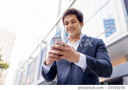 Portrait of confident businessman with mobile phone outdoors Portrait of confident businessman with mobile phone outdoors 33569298