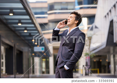 Portrait of confident businessman with mobile phone outdoors Portrait of confident businessman with mobile phone outdoors 33569391