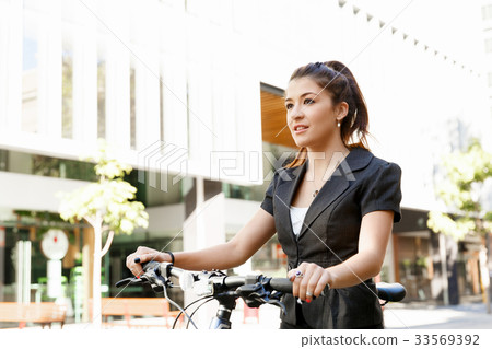 Young woman commuting on bicycle Young woman commuting on bicycle 33569392