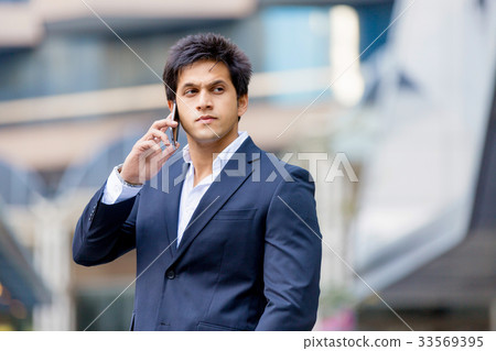 Portrait of confident businessman with mobile phone outdoors 33569395
