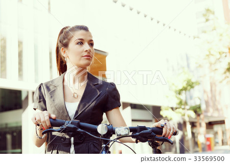 Young woman commuting on bicycle Young woman commuting on bicycle 33569500