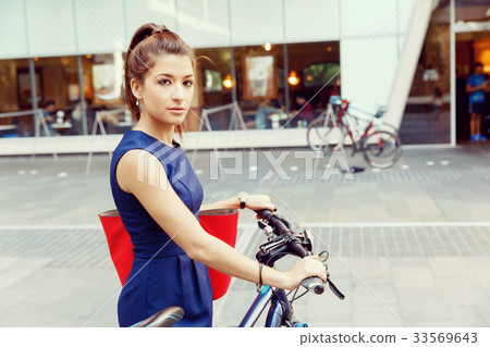 Young woman commuting on bicycle Young woman commuting on bicycle 33569643