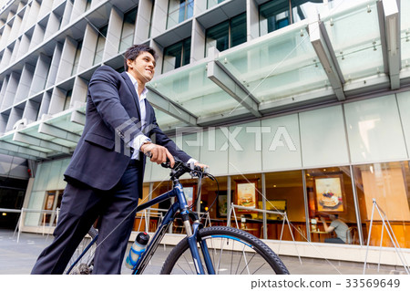 Successful businessman riding bicycle Successful businessman riding bicycle 33569649