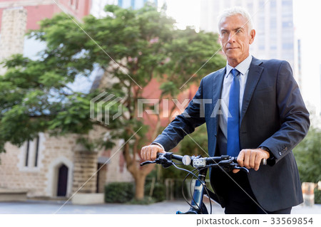 Successful businessman riding bicycle 33569854
