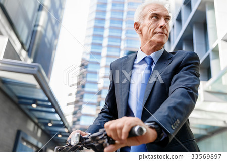 Successful businessman riding bicycle Successful businessman riding bicycle 33569897
