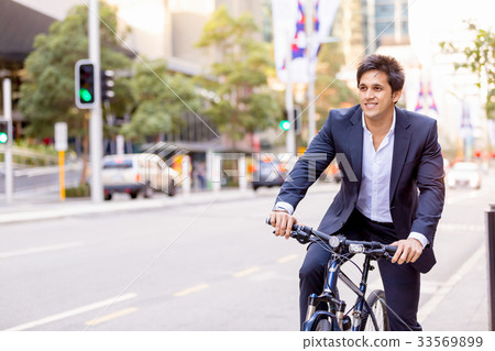 Successful businessman riding bicycle Successful businessman riding bicycle 33569899