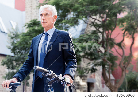 Successful businessman riding bicycle Successful businessman riding bicycle 33569966