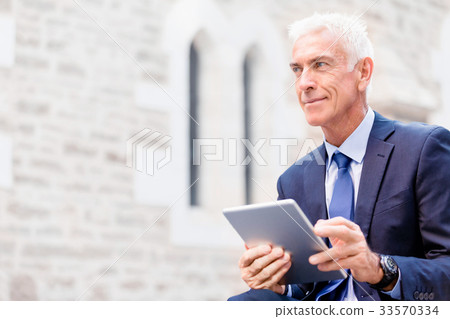 Senior businessman holding touchpad 33570334
