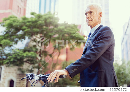 Successful businessman riding bicycle 33570372