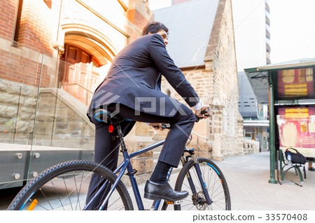 Successful businessman riding bicycle 33570408