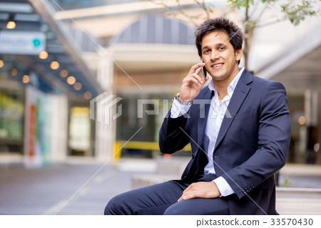 Portrait of confident businessman with mobile phone outdoors Portrait of confident businessman with mobile phone outdoors 33570430
