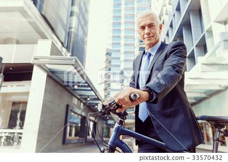 Successful businessman riding bicycle Successful businessman riding bicycle 33570432