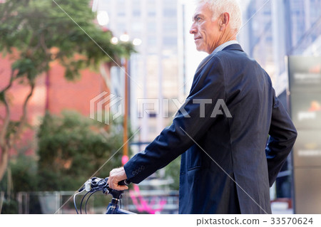 Successful businessman riding bicycle 33570624