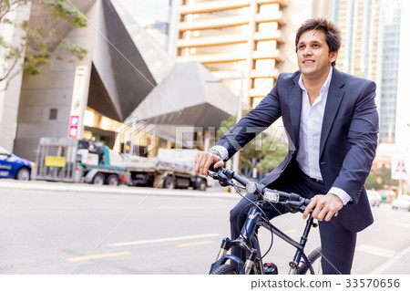 Successful businessman riding bicycle 33570656