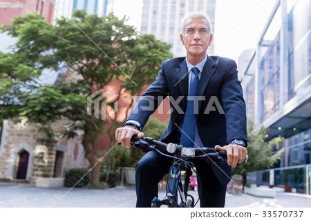 Successful businessman riding bicycle 33570737