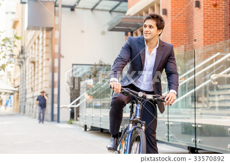 Successful businessman riding bicycle Successful businessman riding bicycle 33570892