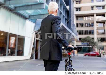 Successful businessman riding bicycle Successful businessman riding bicycle 33571852