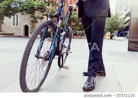 Successful businessman riding bicycle Successful businessman riding bicycle 33572110