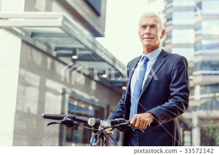 Successful businessman riding bicycle 33572142
