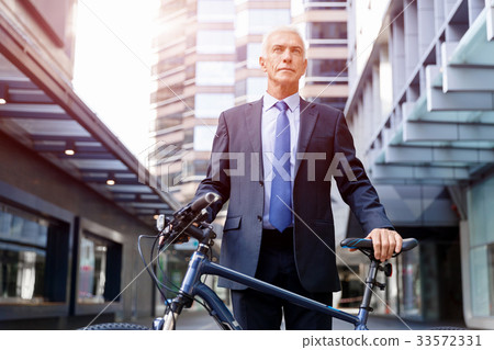Successful businessman riding bicycle 33572331