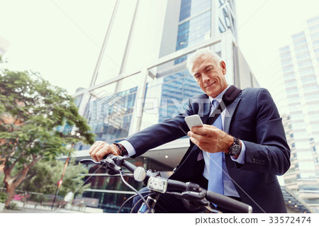 Successful businessman riding bicycle Successful businessman riding bicycle 33572474