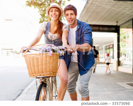Happy couple in city with bike Happy couple in city with bike 33573098