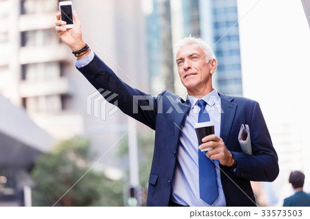 Businessman catching taxi in city 33573503