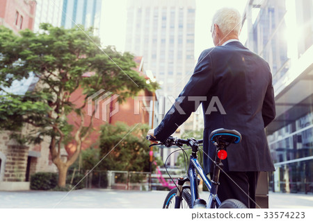 Successful businessman riding bicycle Successful businessman riding bicycle 33574223