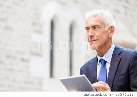 Senior businessman holding touchpad 33575182
