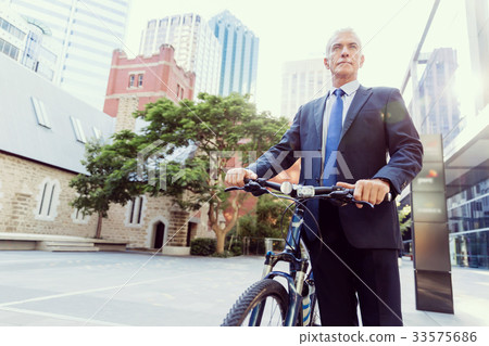 Successful businessman riding bicycle Successful businessman riding bicycle 33575686