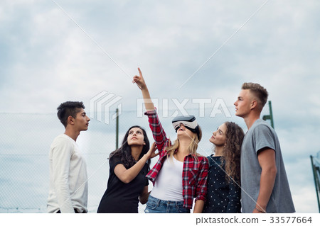 Attractive teenagers on playground. Girl with VR 33577664