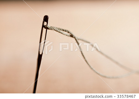 Detail of a Needle with Thread in the Workroom. Detail of a Needle with Thread in the Workroom. 33578467