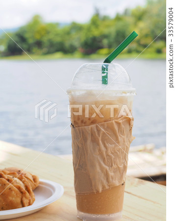 ice coffee with curry on wooden table. 33579004