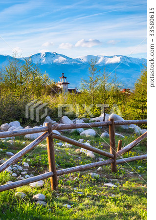 Spring landscape wooden fence, snowy mountain peak Spring landscape wooden fence, snowy mountain peak 33580615