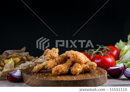 Chicken breast nuggets with vegetables on wooden 33581119