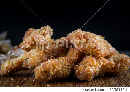Chicken breast nuggets on wooden background. Pile Chicken breast nuggets on wooden background. Pile 33581124