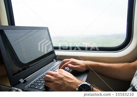 Man working on laptop in a train Man working on laptop in a train 33583210