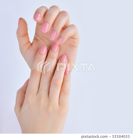 Closeup of hands of young woman with pink manicure Closeup of hands of young woman with pink manicure 33584033