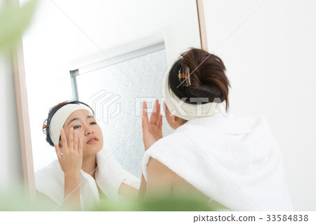 Woman in front of beauty mirror 33584838
