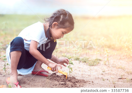 asian child girl having fun to play with sand asian child girl having fun to play with sand 33587736
