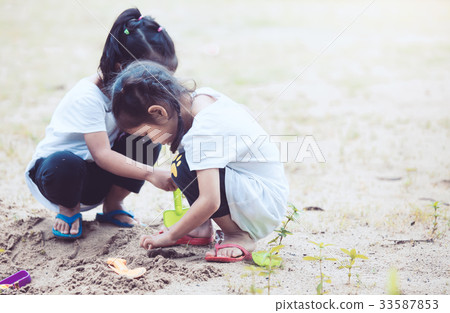 Two asian child girls having fun to play with sand 33587853