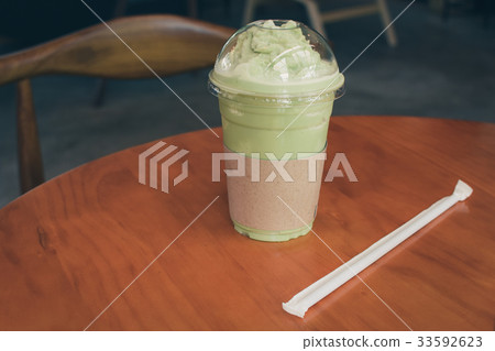 Iced Matcha latte tea on wooden table. 33592623