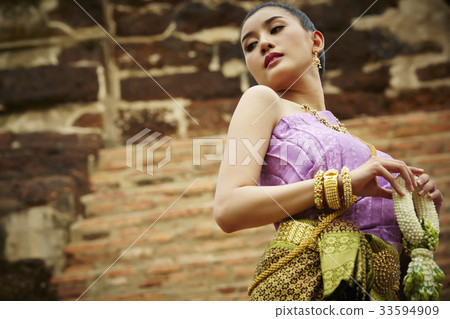 The Thai woman in Thai costume is holding garland on the stair. 33594909