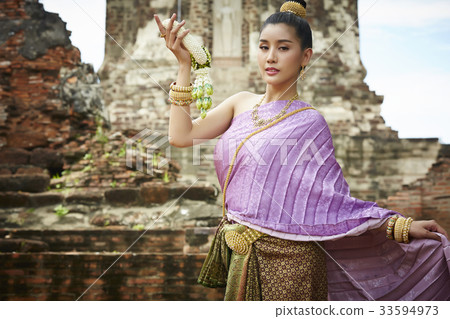 A picture of a woman in Thai costume holding a garland 33594973